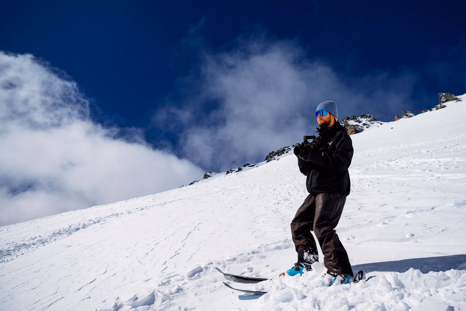 Cinematographer filming on skis on a steep snow slope