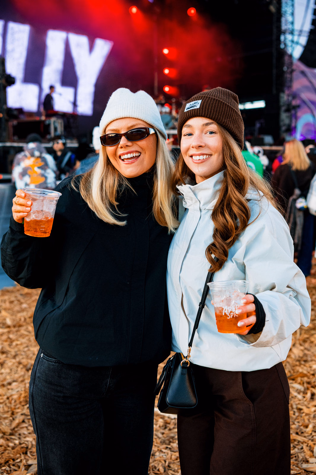 Two friends with drinks at the outdoor stage