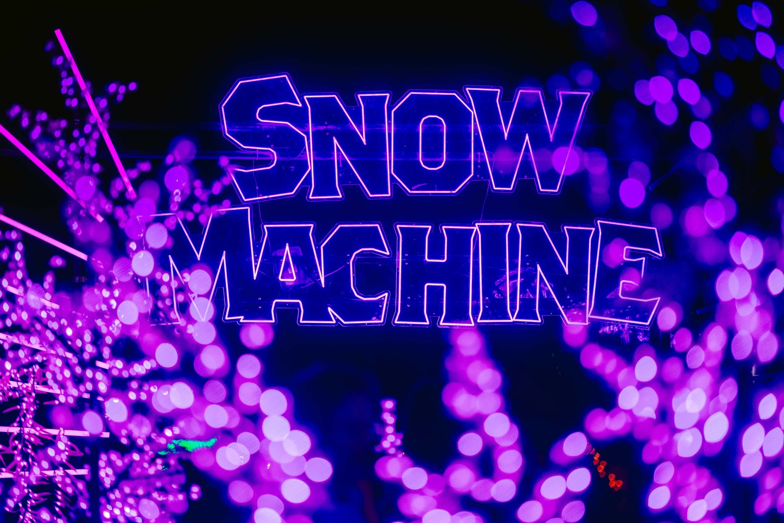 Purple Snow Machine neon sign at night